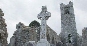 An ancient Celtic cross among the ruins of an ancient Irish church.